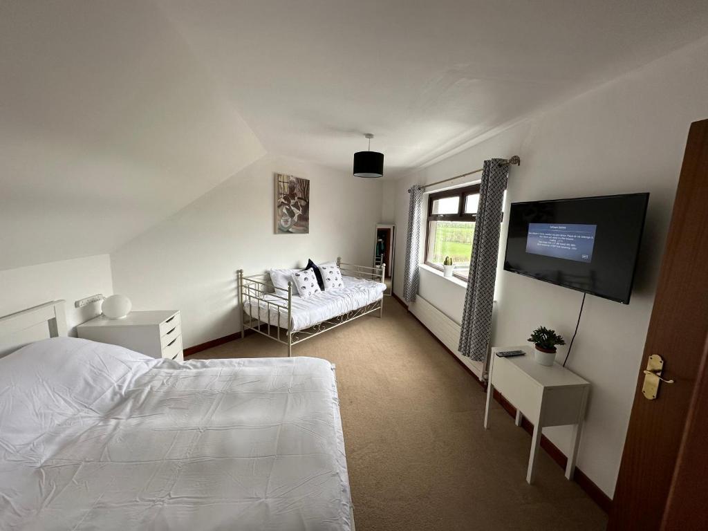 a bedroom with a bed and a flat screen tv at Hill Top House 