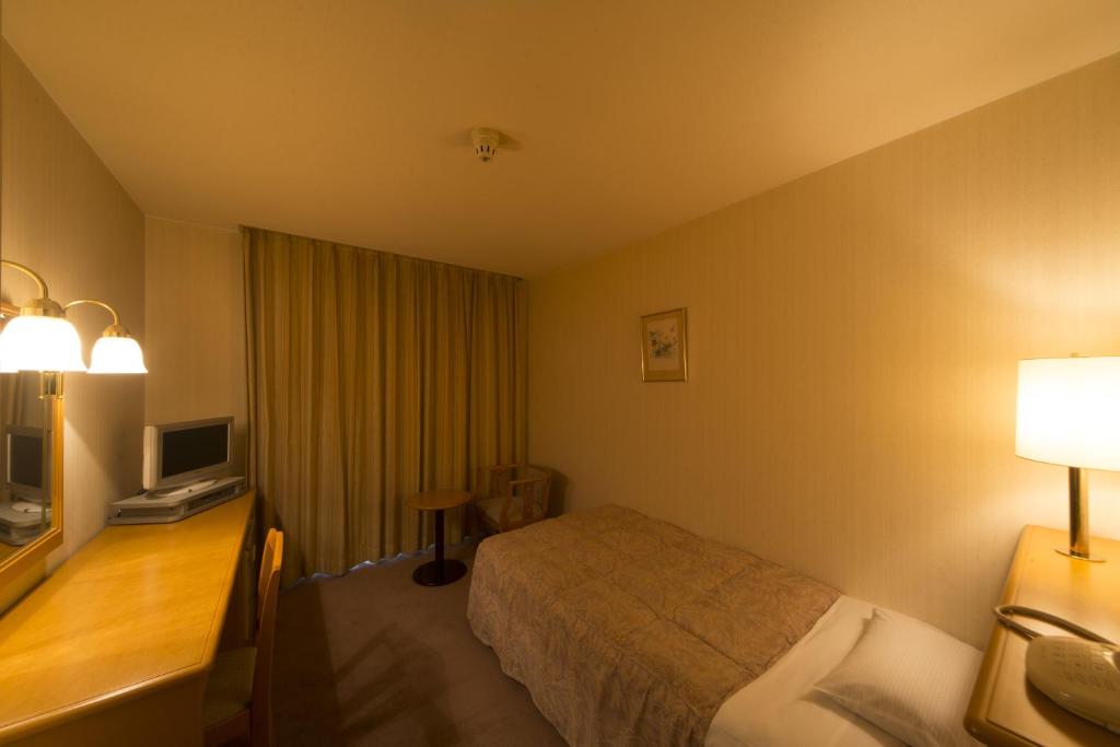 Postel nebo postele na pokoji v ubytování Sky Hotel Uozu Annex