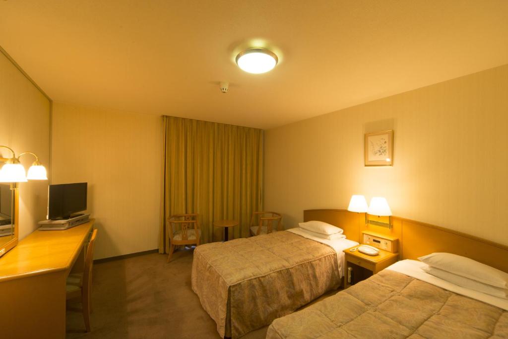 Postel nebo postele na pokoji v ubytování Sky Hotel Uozu Annex