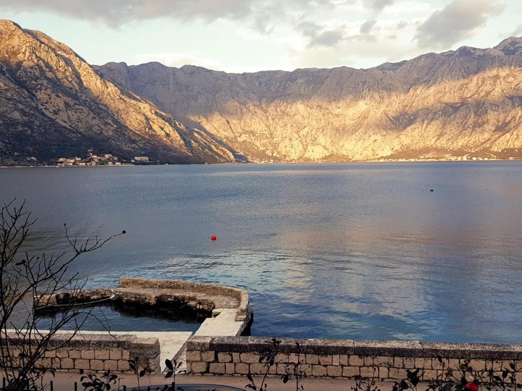 a view of a large body of water with mountains at Sunny Bay House in Kotor