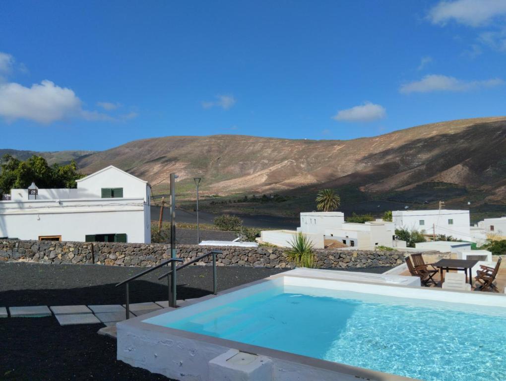 a swimming pool with a view of a house and mountains at Apartamento PANCHO in Tabayesco