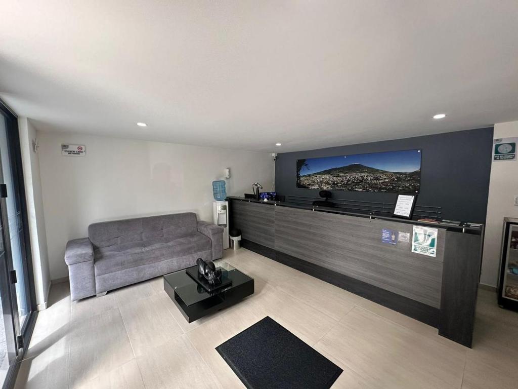 een woonkamer met een bank en een flatscreen-tv bij HOTEL JARDIN 38 in Pasto