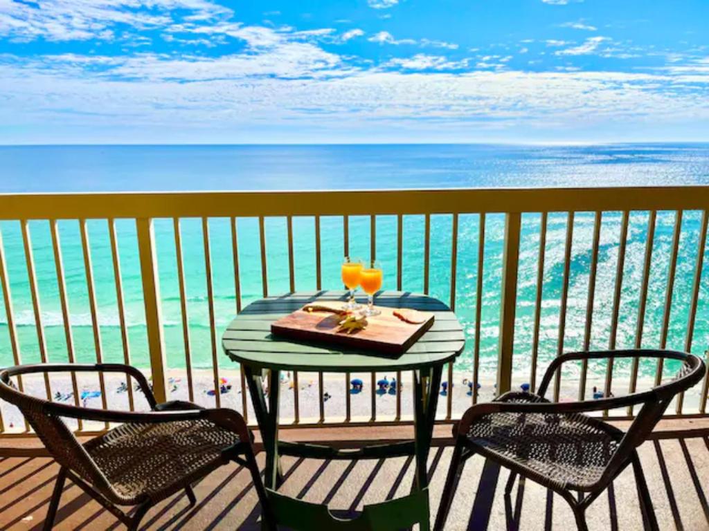 una mesa con una bebida y 2 sillas en el balcón en Beach Front 16th Flr, Best Ocean View, New Upgrades, en Destin