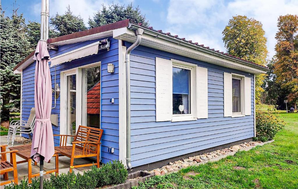 una pequeña casa azul con mesa y sillas en Nice Home In Heidesee With House Sea View, en Heidesee