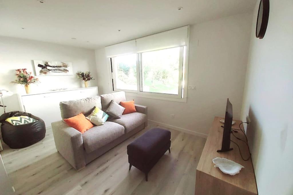 uma sala de estar com um sofá e uma janela em Appartement à Hendaye avec piscine et à côté de la plage em Hendaye