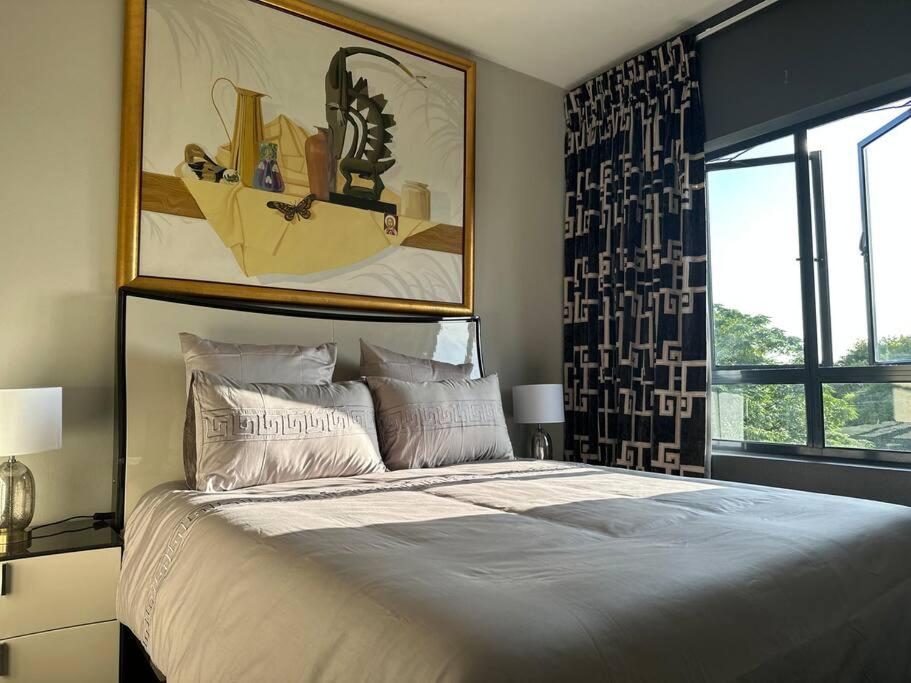 a bedroom with a large bed and a large window at D&DLuxury Rivonia Apartments with inverter in Johannesburg
