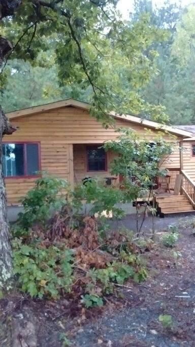 Cabaña de madera con porche y terraza en Rustic Quaint Cabin In the woods--Pets welcomed, en Dunnsville