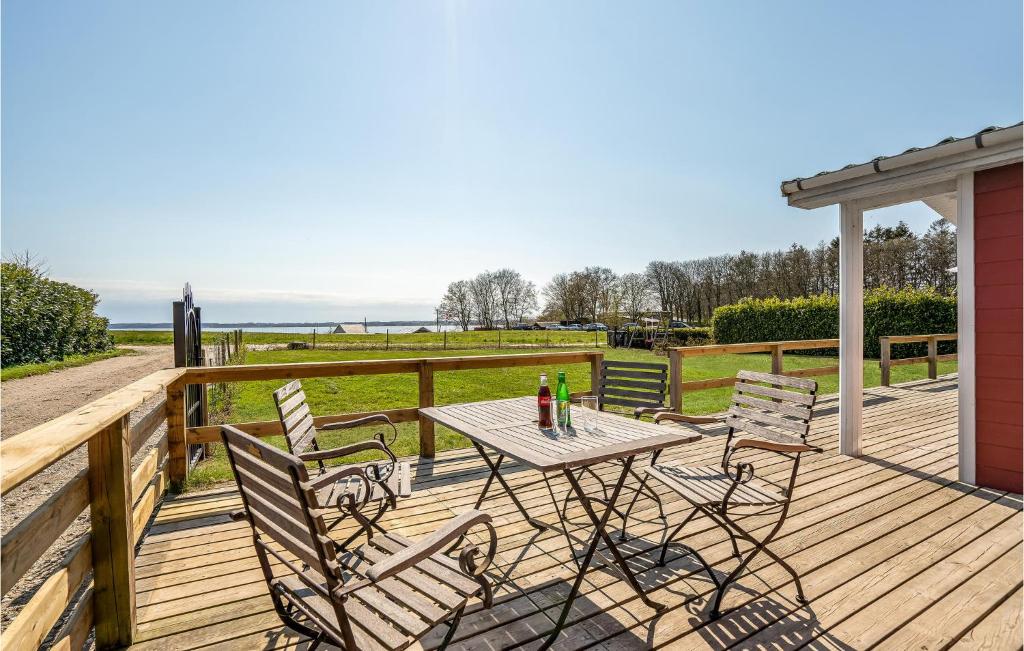 una terrazza in legno con tavolo e sedie. di Beautiful Home In Prst With House Sea View a Stavreby