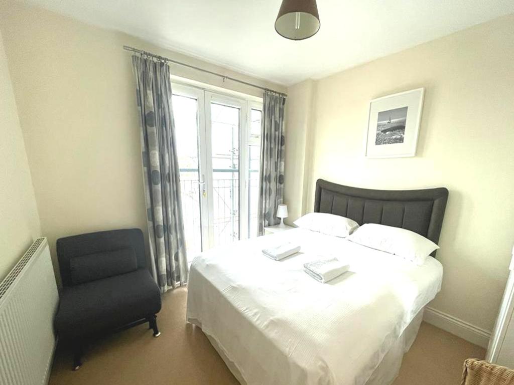 ein Schlafzimmer mit einem Bett, einem Stuhl und einem Fenster in der Unterkunft Lovely Central London Apartment in London