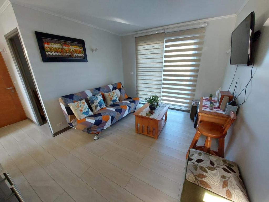 sala de estar con sofá y mesa en Hermoso departamento nuevo en Pucon equipado con 3 dormitorios wifi y estacionamiento privado a 5 minutos del centro y lago en Pucón