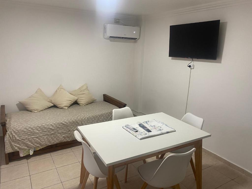 a small room with a bed and a table with chairs at Departamento av.Cordoba in San Juan