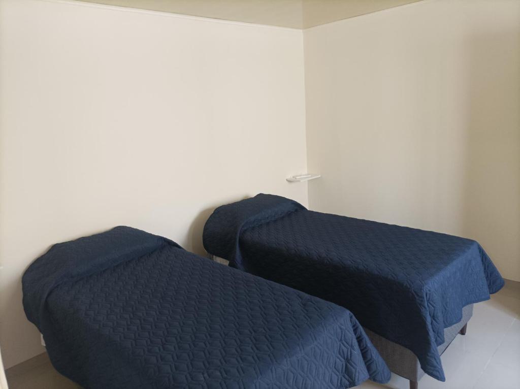 two beds in a room with blue sheets at Lavalleja 71 in Mercedes