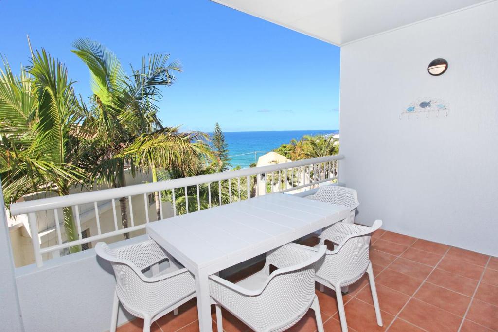 un tavolo bianco e sedie su un balcone con vista sull'oceano di Unit 9 Coolum Blueseas a Coolum Beach