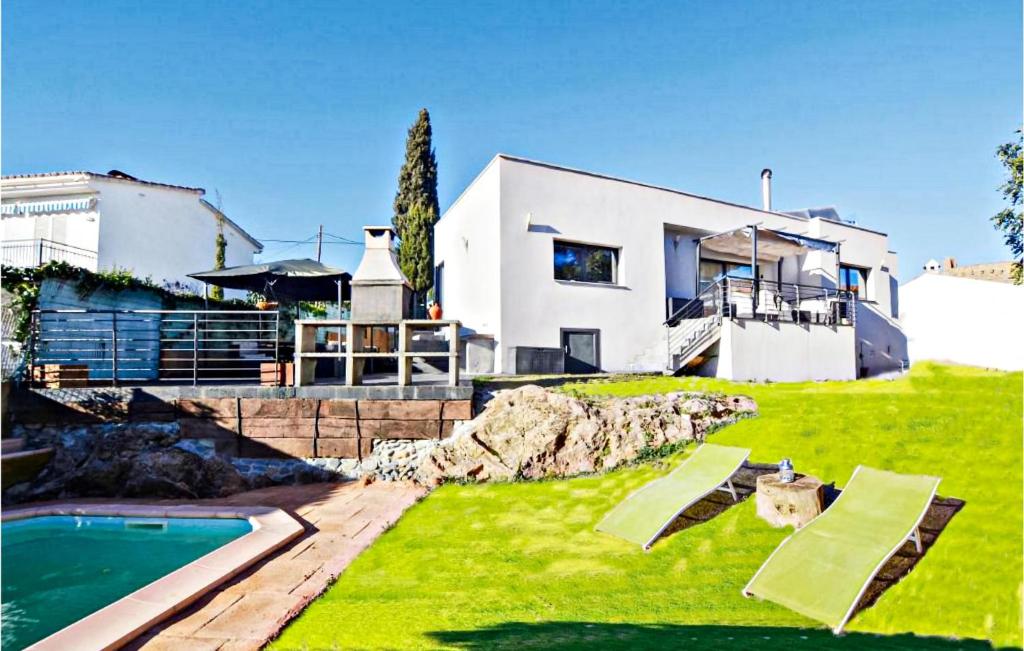 a house with a swimming pool in front of a yard at Amazing Home In Santa Susanna With Kitchen in Santa Susanna