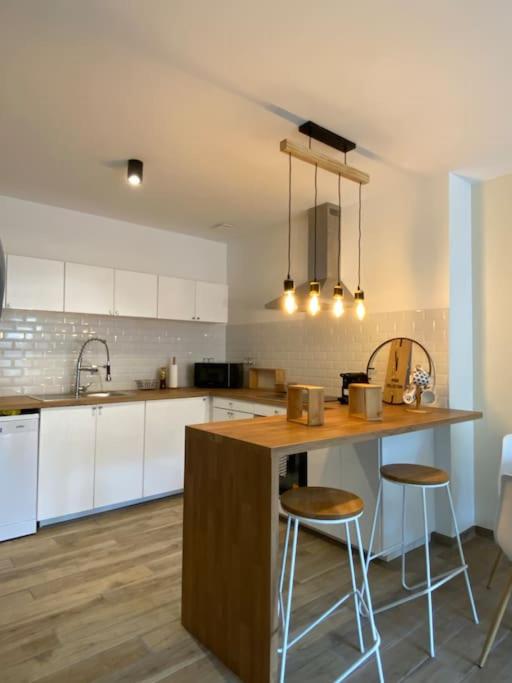 a kitchen with a counter and two stools in it at Charmante Maison dans le Vieux Douai in Douai