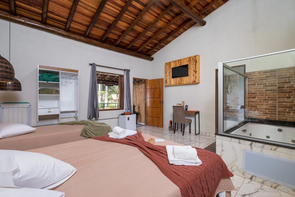 1 Schlafzimmer mit 2 Betten und einer Badewanne in der Unterkunft Pousada Pitauá in Socorro