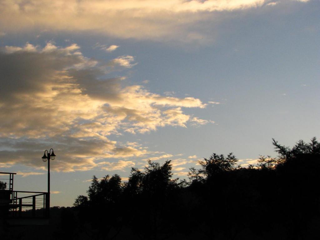 a cloudy sky with trees and a street light at Ying Shih Guest House in Datong