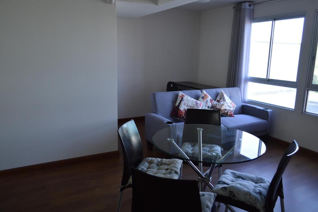 uma sala de estar com uma mesa de vidro e um sofá azul em Hermoso departamento en exclusivo Condominio em Arequipa
