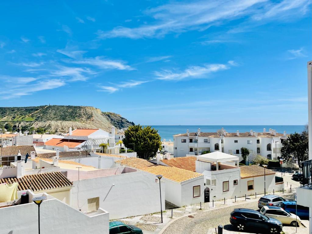 Blick auf eine Stadt mit Häusern und das Meer in der Unterkunft Apartamento Maria Fernanda, in the Centre of Luz in Luz