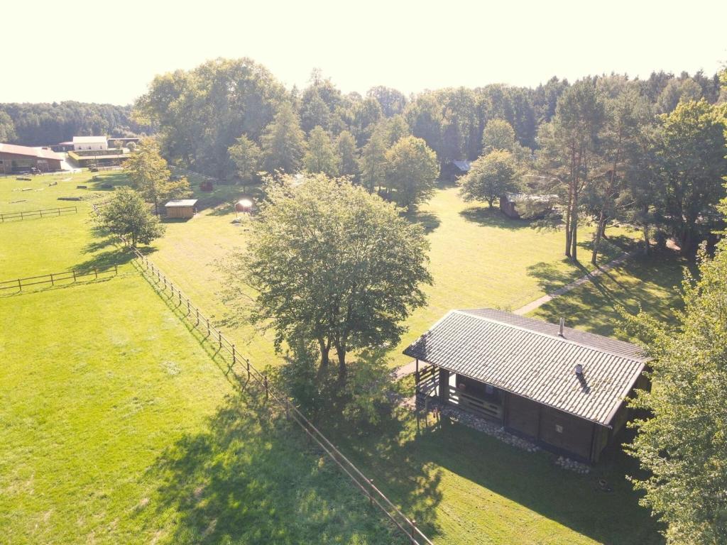 eine Aussicht auf ein Haus auf einem Feld in der Unterkunft Cozy holiday home on a horse farm in the Lüneburg Heath in Eschede