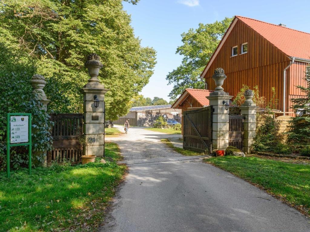una entrada con una puerta y un granero rojo en Cozy holiday home on a horse farm in the Lüneburg Heath, en Eschede