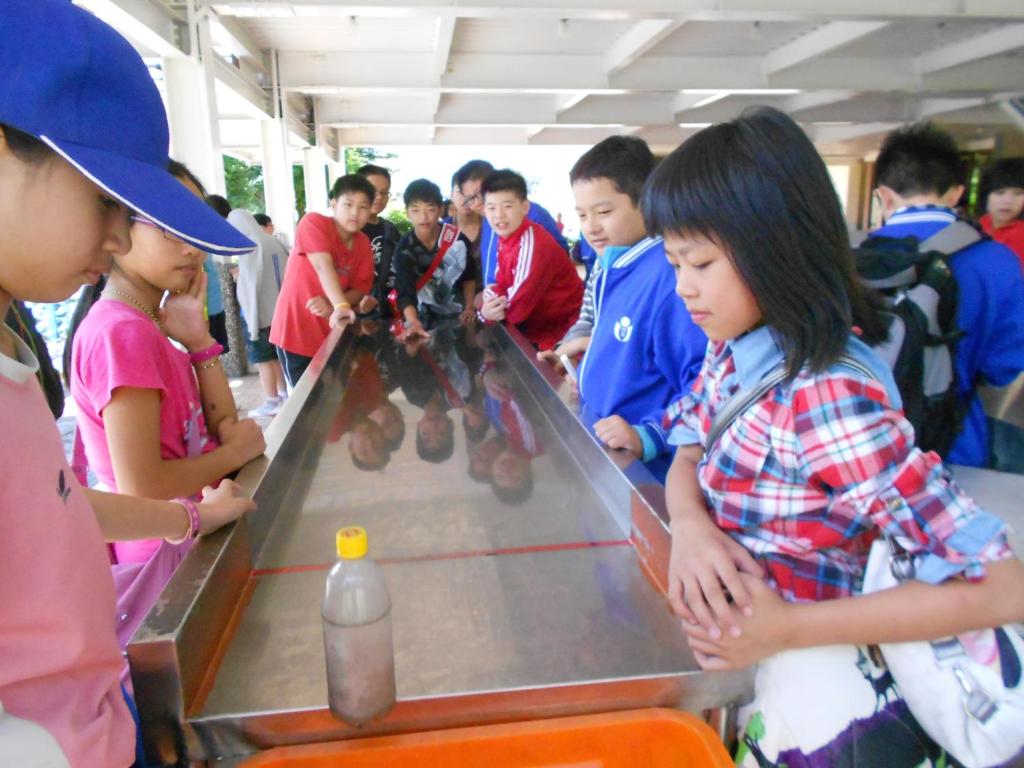 a group of children standing around a table with a video game at Ying Shih Guest House in Datong