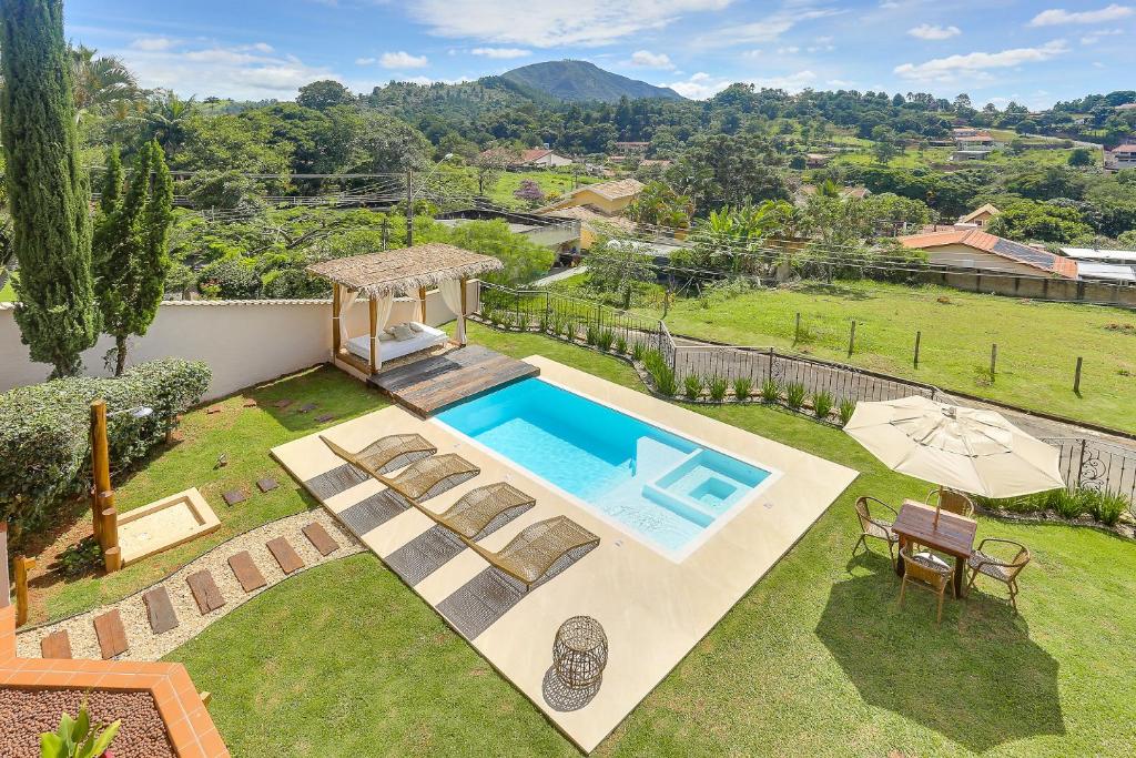 a backyard with a swimming pool and a garden at Villa Boréal Hostellerie in Águas de Lindoia