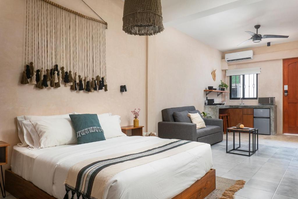 a bedroom with a bed and a chair in a room at Rodina Boutique Hotel in Playa del Carmen