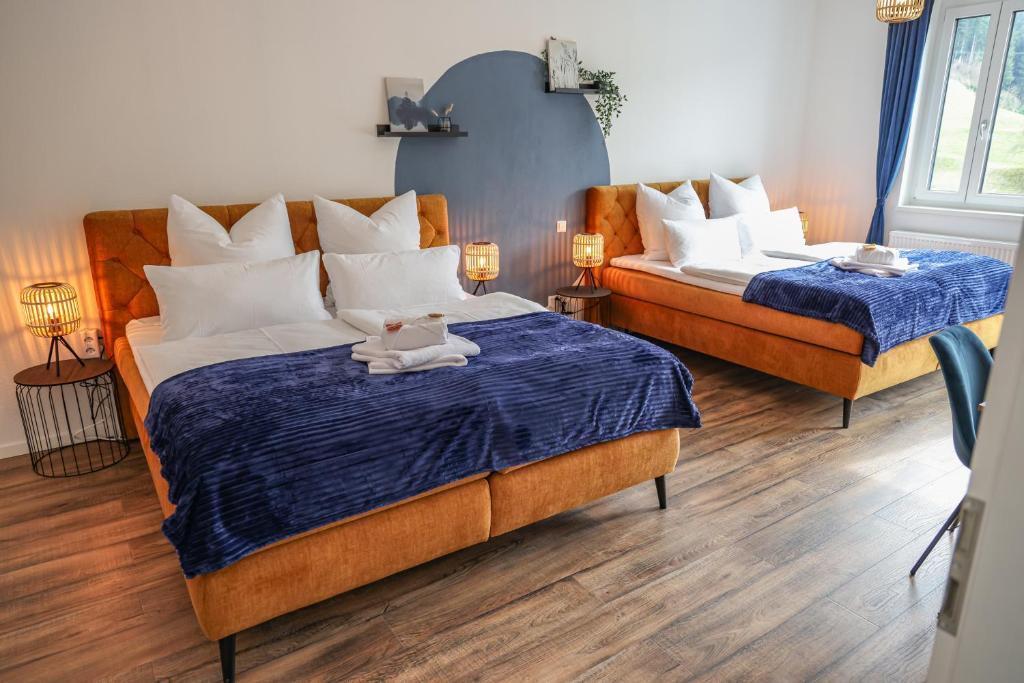 1 dormitorio con 2 camas con sábanas azules y blancas en Penthouse I 85 qm I Boxspring I Balkon I Nespresso, en Oberharmersbach