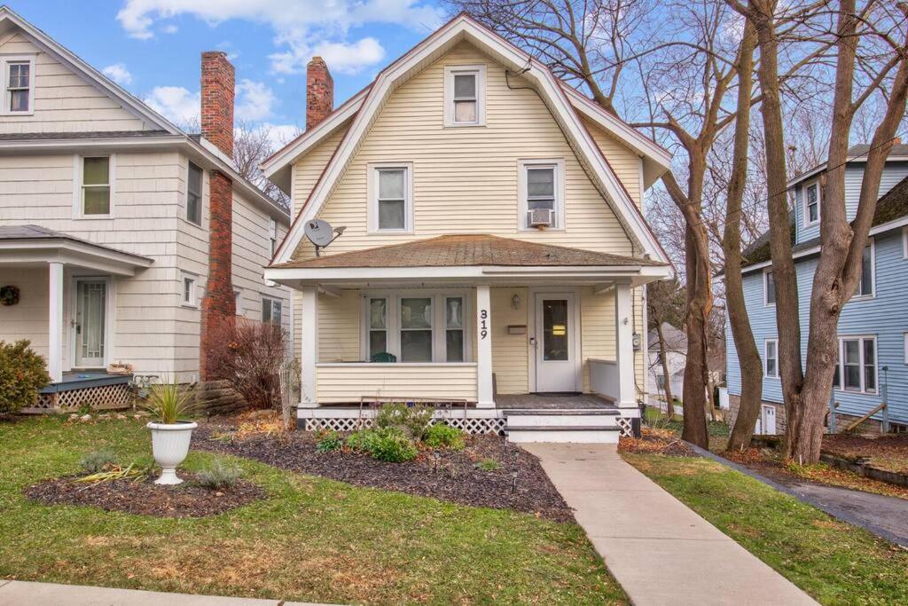 ein weißes Haus mit einer Veranda und einer Auffahrt in der Unterkunft Charming Cuse home close to downtown & university in Syracuse