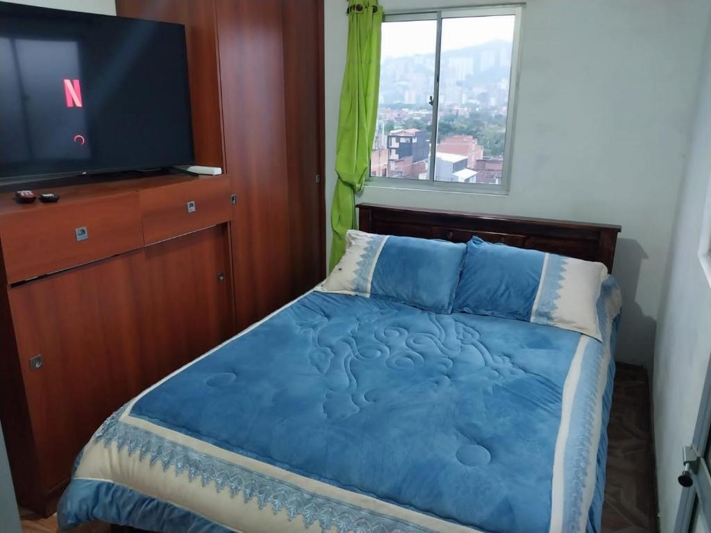 a bedroom with a bed and a flat screen tv at Los balcones lll in Medellín
