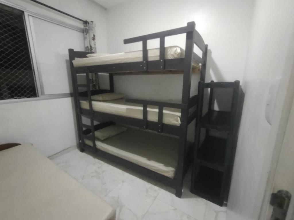 a room with bunk beds in a room at Apartamento mobiliado prédio frente ao mar in São Vicente
