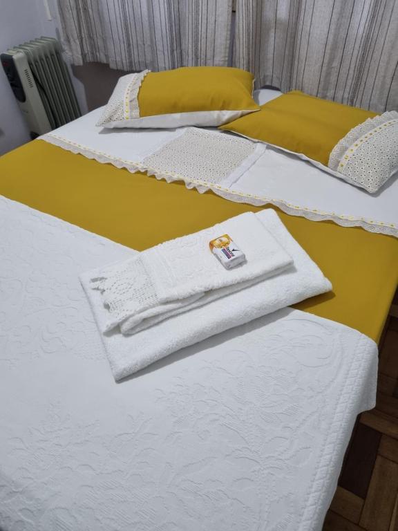 2 Betten mit weißen Handtüchern darüber in der Unterkunft CASA DO PINHEIRO 2 in Chapecó
