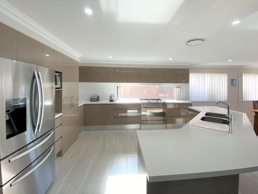 a kitchen with a stainless steel refrigerator and cabinets at Pardesa A Little Piece Of Paradise - Belle Escapes Jervis Bay in St Georges Basin