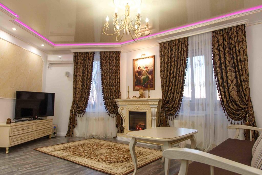 een woonkamer met een open haard en een televisie bij Versal Apartments in Krementsjoek