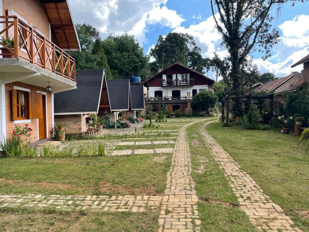 a house with a brick path in front of a yard at Flor da Montanha in Monte Verde