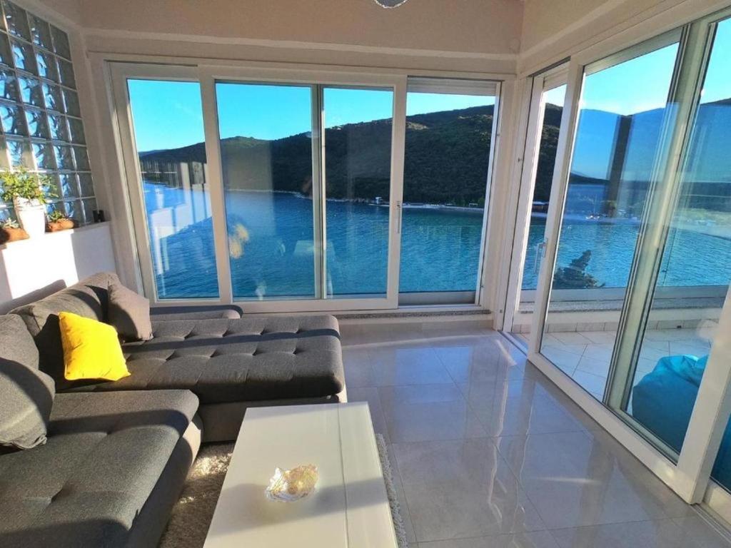 un soggiorno con divano e ampie finestre di Apartment Beautifull View a Rabac