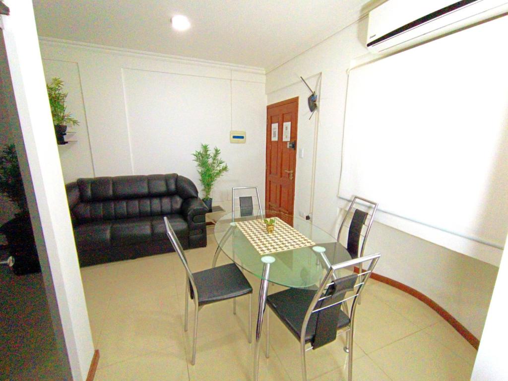 ein Wohnzimmer mit einem Tisch, Stühlen und einem Sofa in der Unterkunft Departamentos en Edificio Acrebol Santa Cruz in Santa Cruz de la Sierra