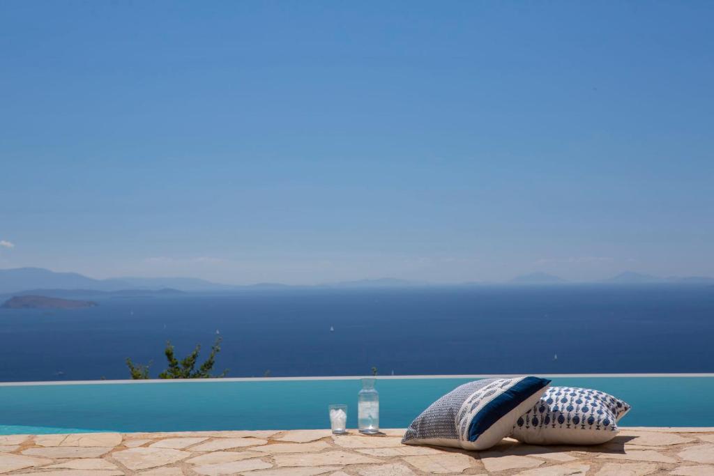 two pillows sitting on a table next to a pool at Villa Evalin - Pretty Villa Like at Home for Unforgettable Holidays in Sivota