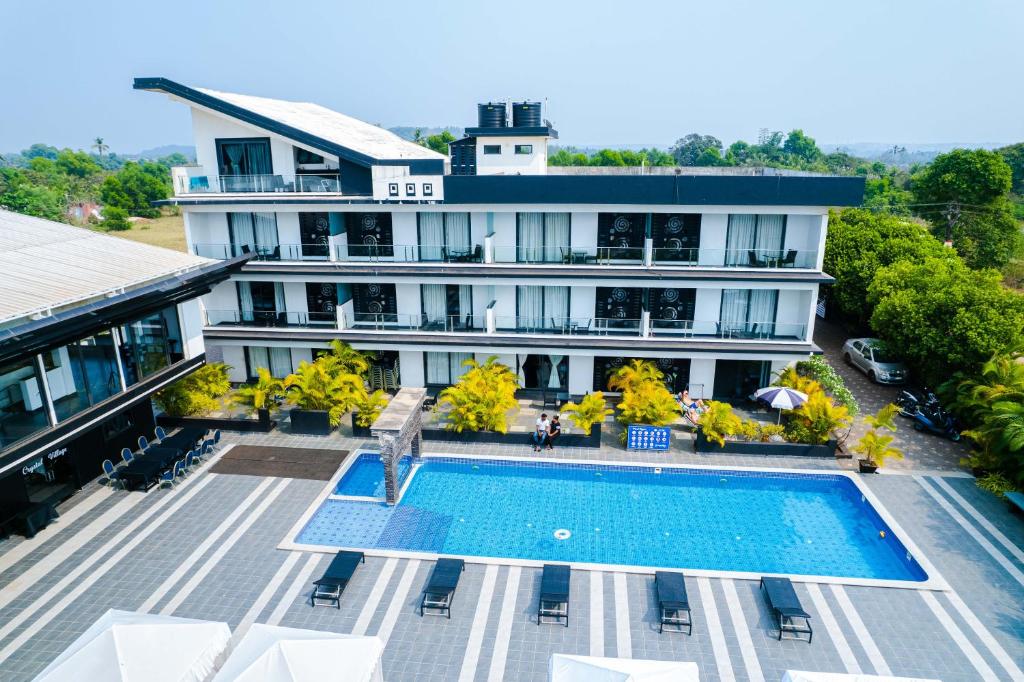 uma vista aérea de um hotel com uma piscina em Crystal Village em Nagoa-Bardez