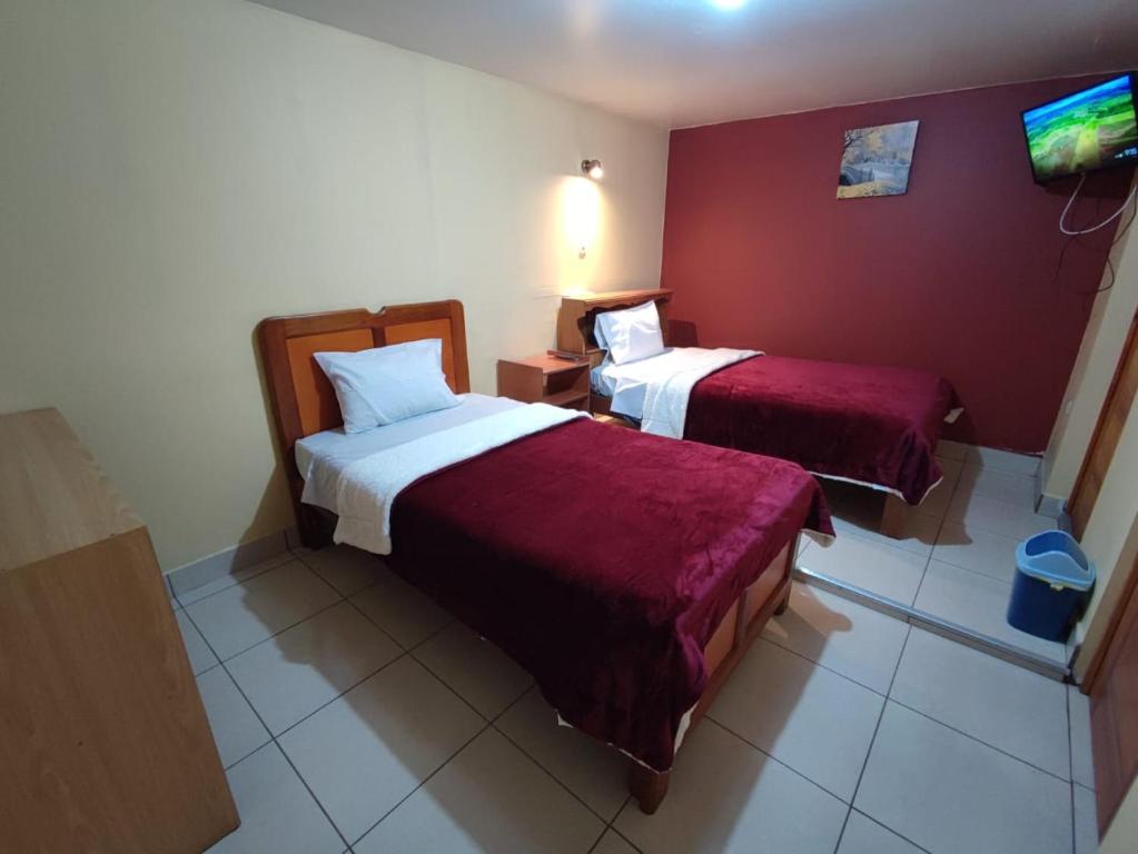 um quarto de hotel com duas camas e uma televisão em Casa particular em Arequipa