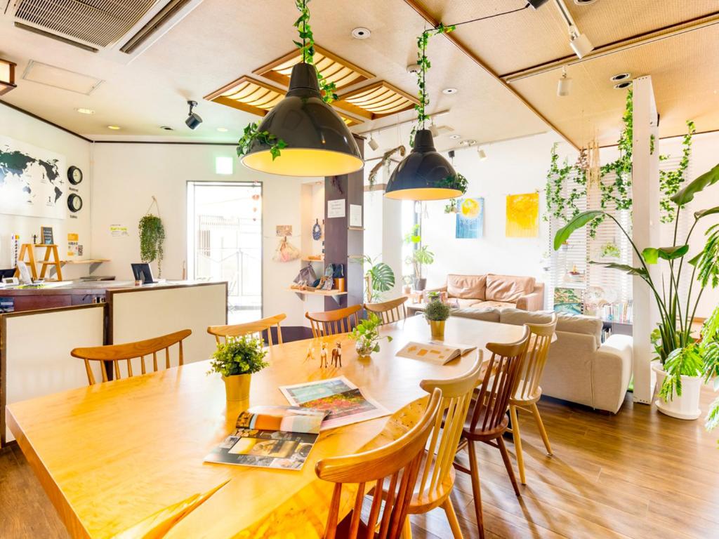 a dining room and living room with a table and chairs at Nara Guesthouse 3F in Nara