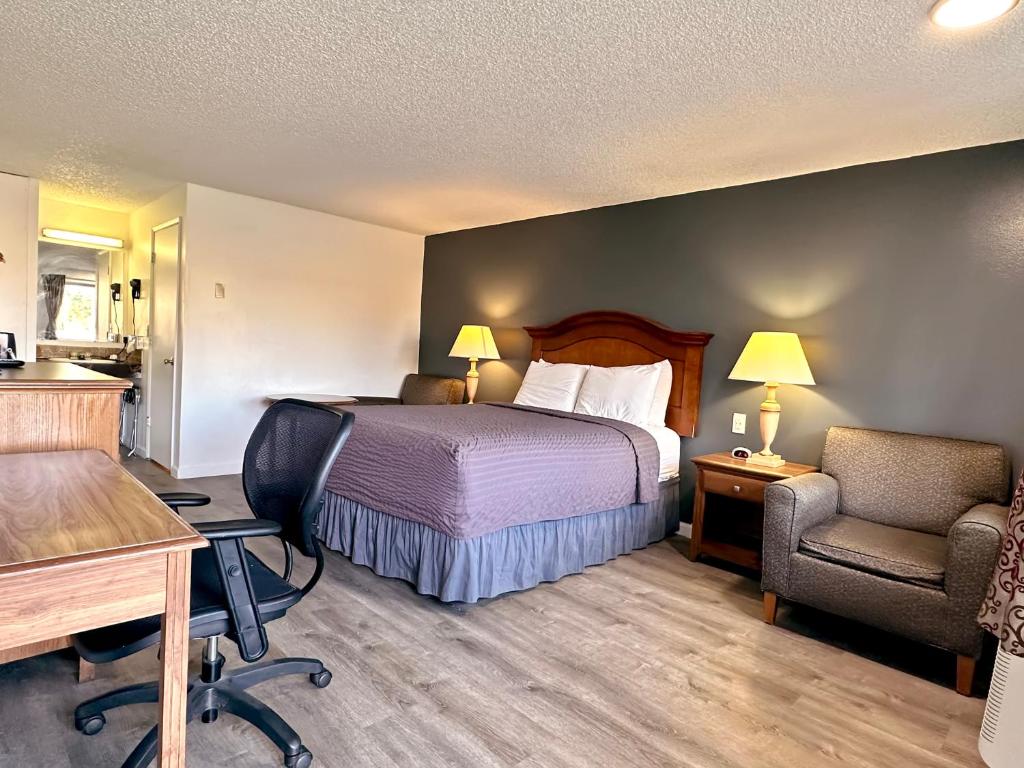 Economy Inn في فلورنس: غرفه فندقيه بسرير ومكتب وكرسي