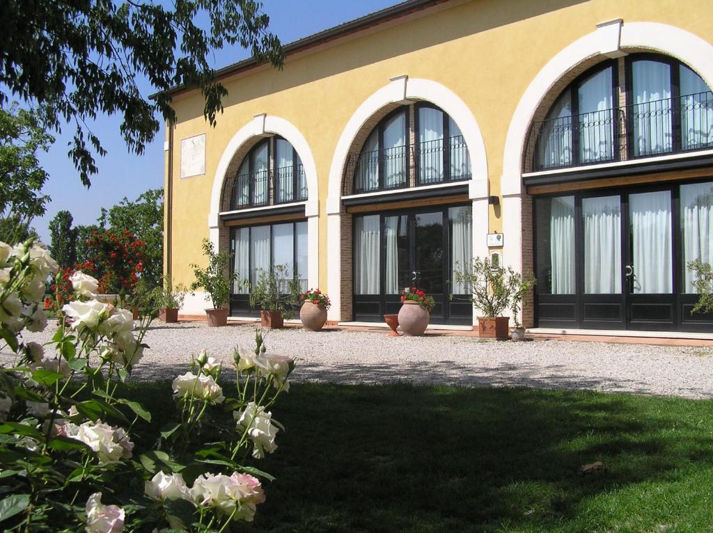 un bâtiment avec des fenêtres et des fleurs devant lui dans l'établissement Fattoria Grimana, à Montegalda