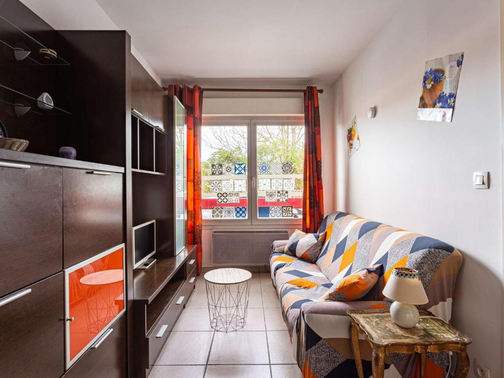 uma pequena sala de estar com um sofá e uma televisão em Appartement Hendaye, 1 pièce, 2 personnes - FR-1-2-421 em Hendaye