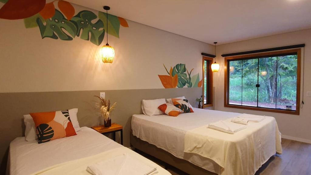 1 Schlafzimmer mit 2 Betten und einem Fenster in der Unterkunft Espaço Canto in Santo Antônio do Pinhal