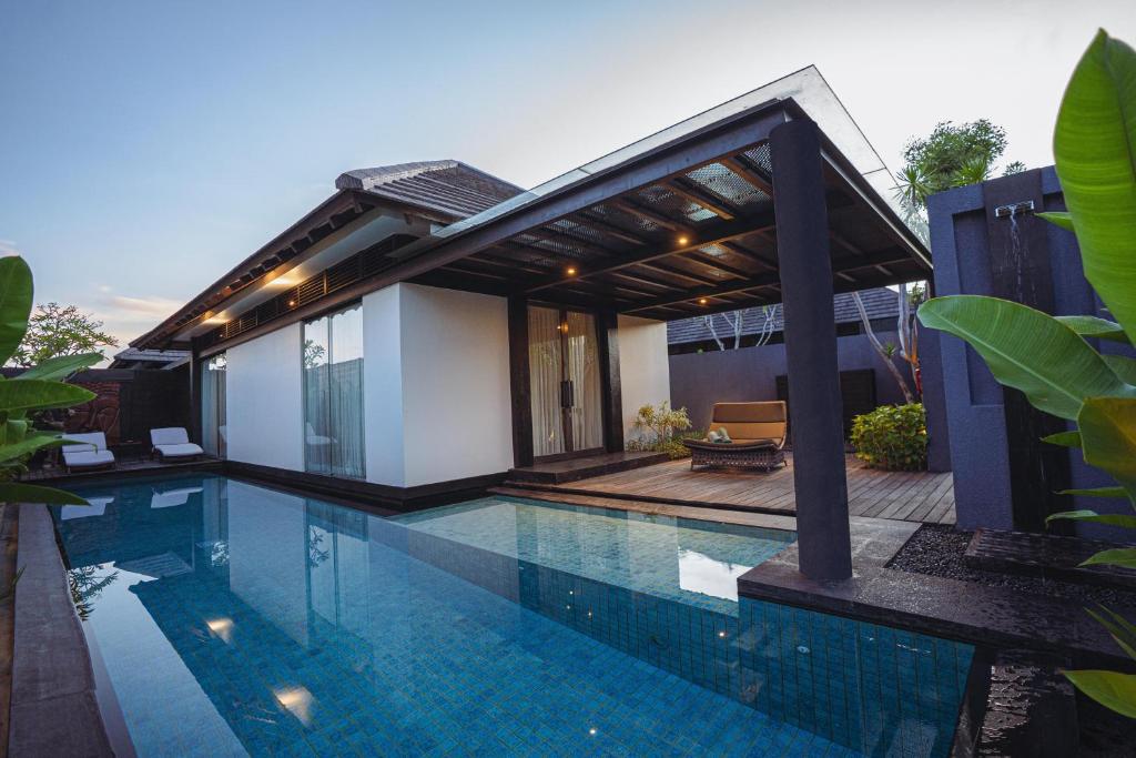 uma casa com piscina em frente a uma casa em Javana Royal Villas em Seminyak