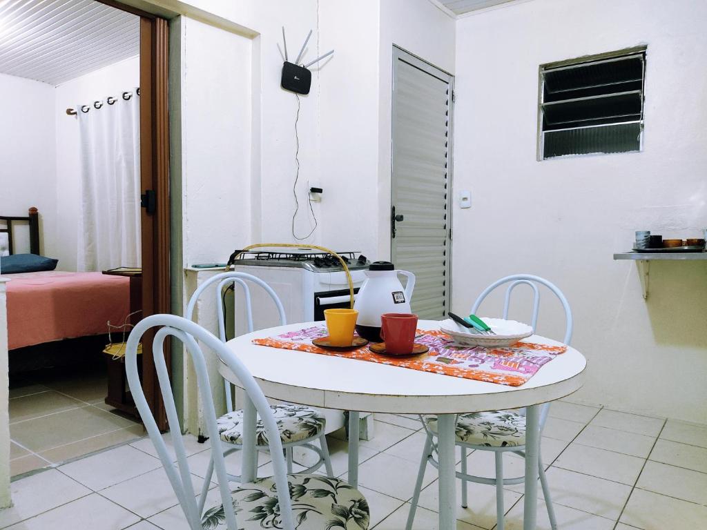 une cuisine avec une table et des chaises ainsi qu'une chambre dans l'établissement Casa Excelente Localização Perto Furg,Praia!, à Rio Grande
