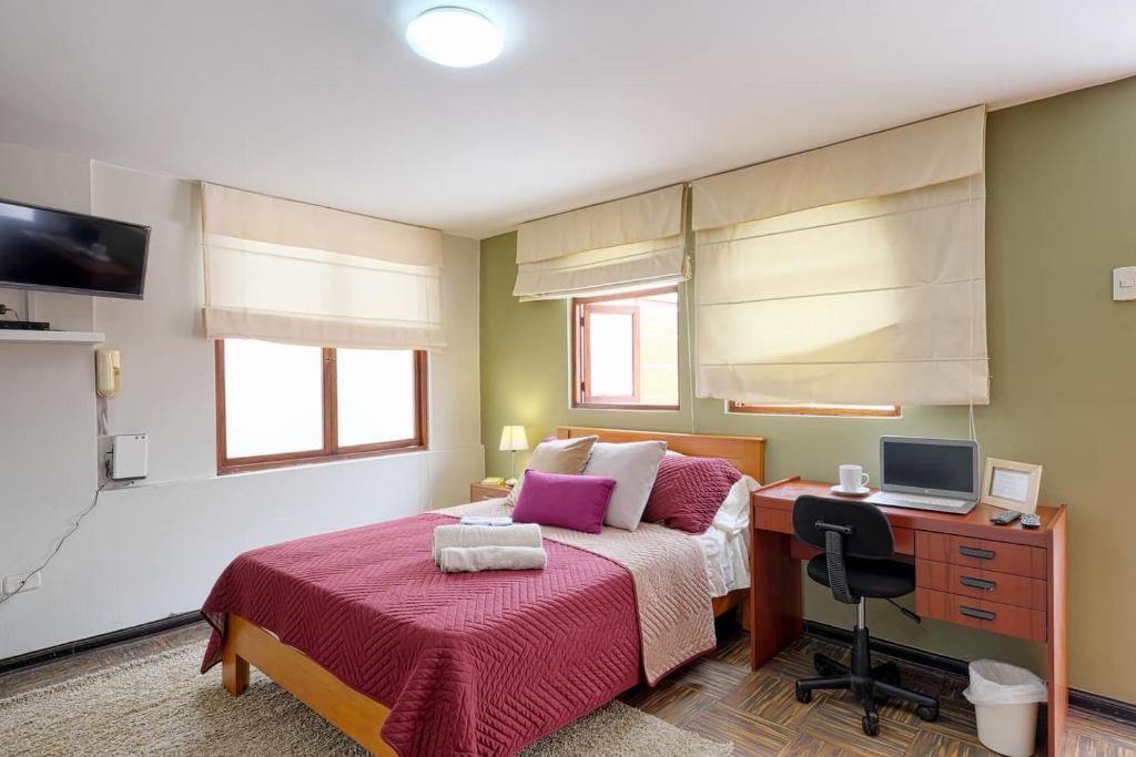 Charming Miraflores Guesthouse with Terrace Studio Apartment and Private Room في ليما: غرفة نوم بها سرير ومكتب مع جهاز كمبيوتر