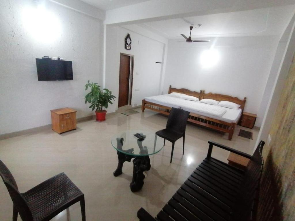 蘇丹布塔里的住宿－Tapovan Farm House，客厅配有床和桌子